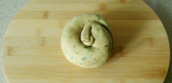 Curl it up into a spiral, with the thicker-dough-end on the outside.